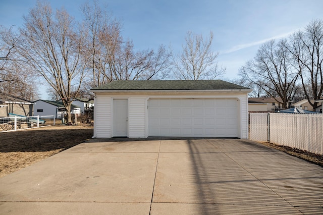 detached garage featuring fence