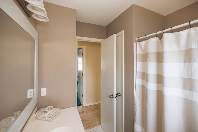 full bathroom with vanity, a shower with curtain, and wood finished floors