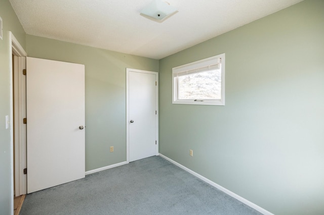 unfurnished bedroom with baseboards and carpet flooring