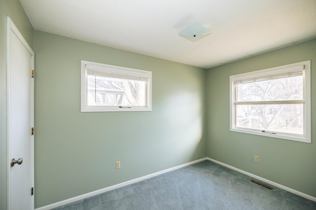 unfurnished room with carpet flooring, baseboards, and visible vents