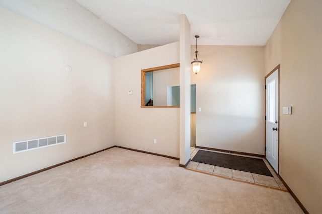 foyer featuring lofted ceiling, baseboards, visible vents, and carpet floors