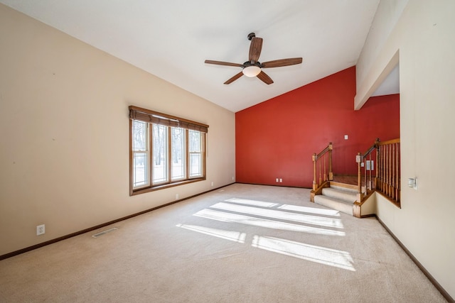 empty room with stairway, baseboards, visible vents, and vaulted ceiling