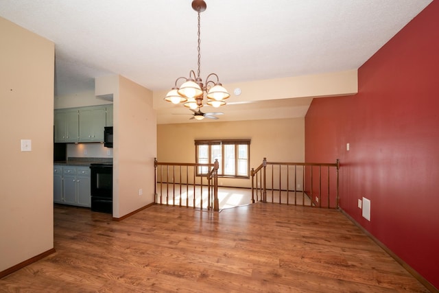 unfurnished dining area with a chandelier, baseboards, and wood finished floors