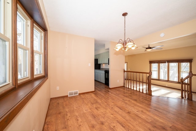 empty room with visible vents, baseboards, a chandelier, and light wood finished floors