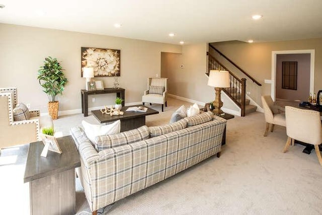 living area with recessed lighting, light carpet, stairway, and baseboards