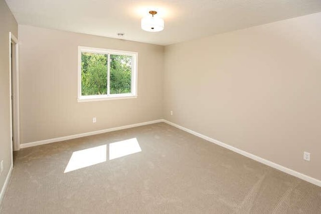 carpeted spare room with baseboards