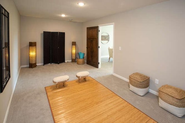 sitting room featuring light carpet and baseboards