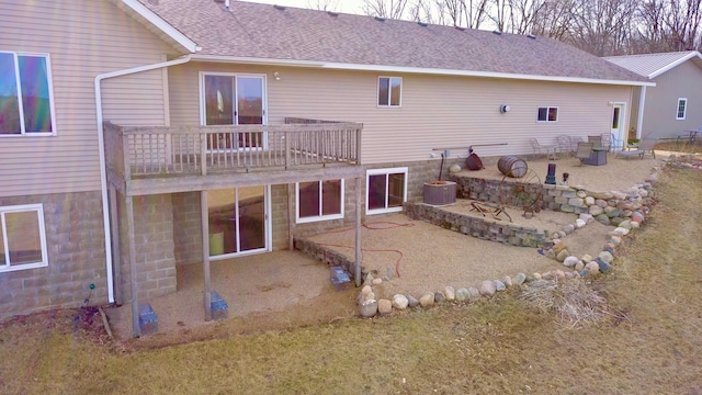 back of property featuring a patio and roof with shingles