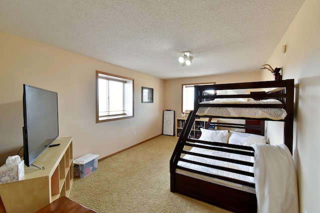 bedroom featuring multiple windows, baseboards, carpet floors, and a textured ceiling