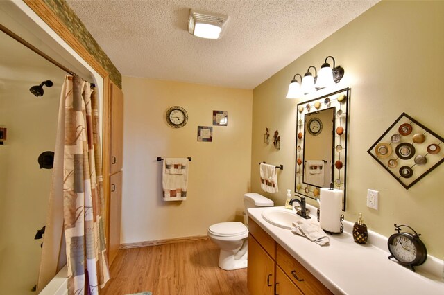 bathroom featuring curtained shower, vanity, toilet, and wood finished floors