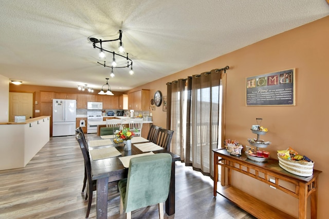 dining room with a textured ceiling and light wood finished floors