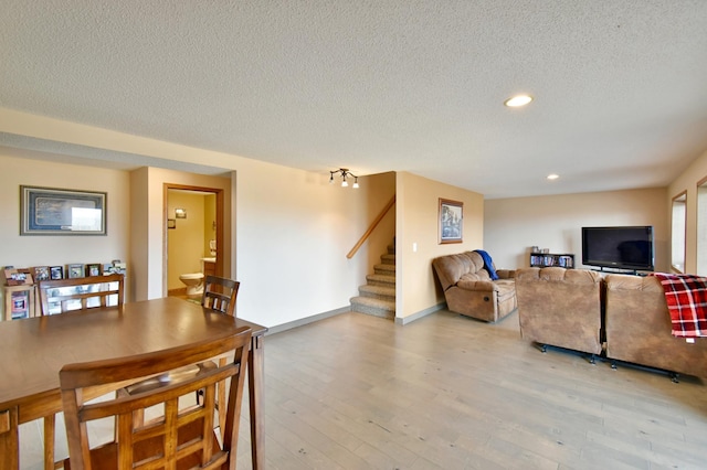 living room with baseboards, stairs, recessed lighting, light wood-style floors, and a textured ceiling