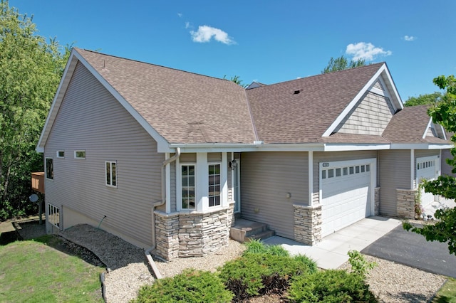 15436 70th Ave N, Maple Grove, MN 55311 - view of front facade featuring an attached garage, stone siding, a shingled roof, and driveway