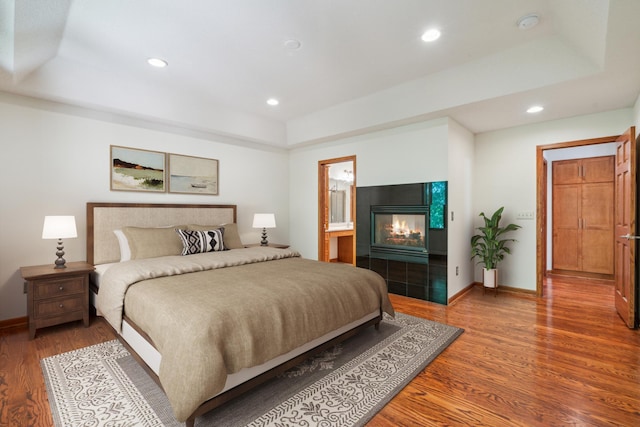 15436 70th Ave N, Maple Grove, MN 55311 - bedroom with a raised ceiling, wood finished floors, a fireplace, baseboards, and recessed lighting