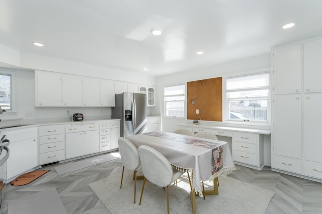 kitchen featuring a sink, recessed lighting, stainless steel refrigerator with ice dispenser, and white cabinetry