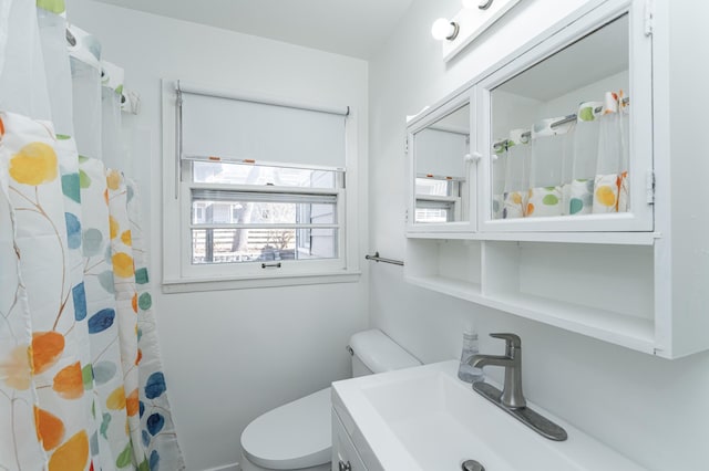 bathroom with a sink, curtained shower, and toilet