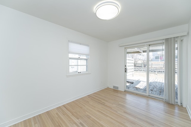 empty room featuring visible vents, baseboards, light wood-style floors, and a healthy amount of sunlight