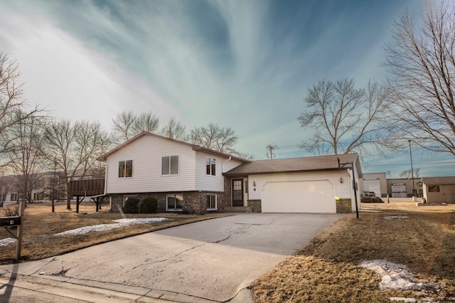 tri-level home with a garage, brick siding, and driveway