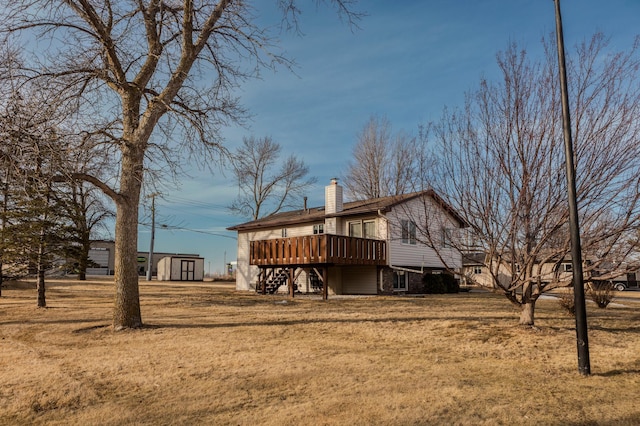 exterior space featuring a deck, an outbuilding, a storage shed, stairway, and a chimney