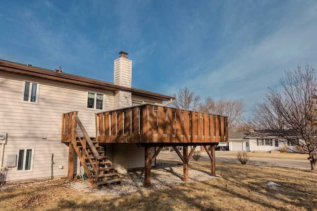 back of property featuring stairs, a chimney, and a wooden deck