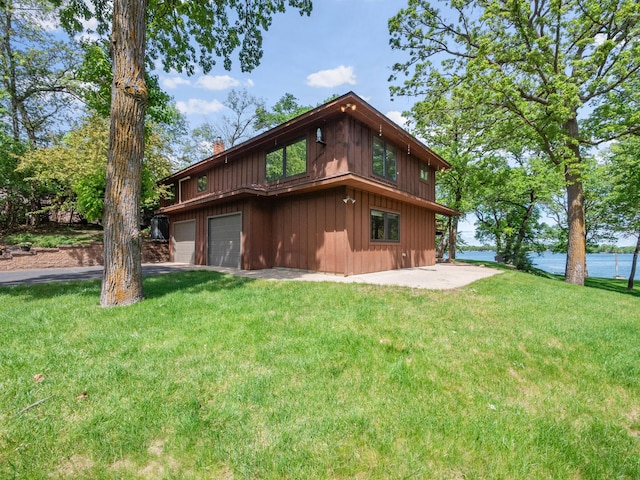 2904 Le Homme Dieu Vw NE, Alexandria, MN 56308 - back of property with a garage, a chimney, a lawn, board and batten siding, and asphalt driveway