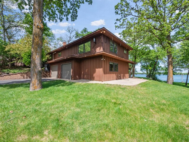 2904 Le Homme Dieu Vw NE, Alexandria, MN 56308 - back of property featuring a chimney, an attached garage, a lawn, board and batten siding, and asphalt driveway