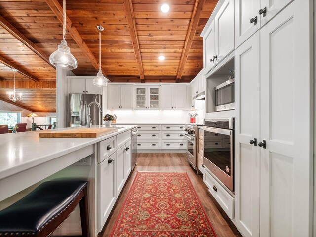 2904 Le Homme Dieu Vw NE, Alexandria, MN 56308 - kitchen featuring wood ceiling with exposed beams, appliances with stainless steel finishes, light countertops, wood finished floors, and decorative light fixtures