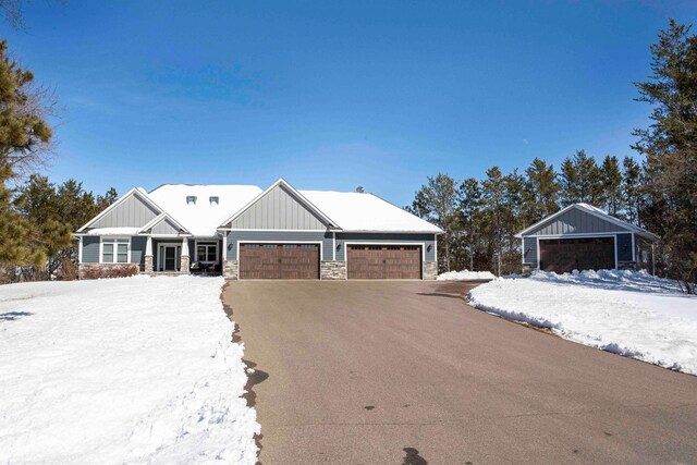 craftsman house featuring stone siding, board and batten siding, and driveway