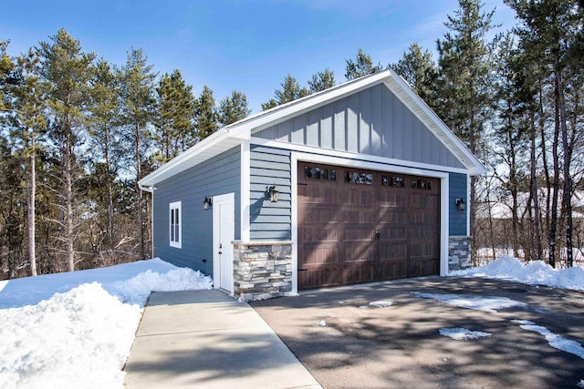 snow covered garage with a detached garage