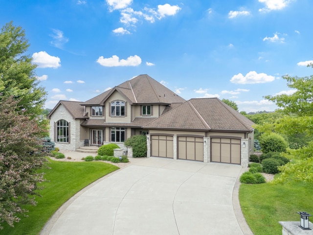 1502 Epperstone Enclave, Byron, MN 55920 - view of front of house featuring an attached garage, driveway, a front lawn, and stone siding