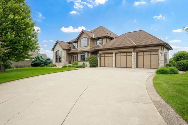 1502 Epperstone Enclave, Byron, MN 55920 - view of front of house featuring a garage, stone siding, concrete driveway, and a front yard