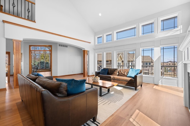 1502 Epperstone Enclave, Byron, MN 55920 - living room featuring arched walkways, high vaulted ceiling, light wood-type flooring, ornate columns, and recessed lighting