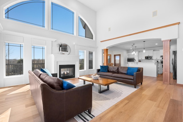 1502 Epperstone Enclave, Byron, MN 55920 - living area featuring ornate columns, light wood-style floors, a towering ceiling, healthy amount of natural light, and recessed lighting