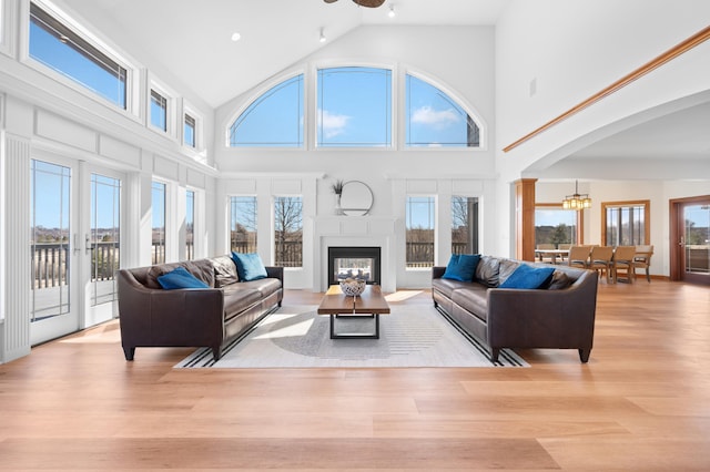 1502 Epperstone Enclave, Byron, MN 55920 - living area with arched walkways, high vaulted ceiling, wood finished floors, a glass covered fireplace, and a chandelier