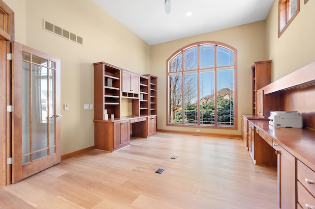 1502 Epperstone Enclave, Byron, MN 55920 - home office featuring built in desk, a towering ceiling, and light wood-style floors