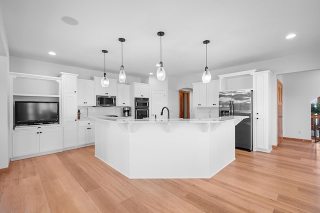 1502 Epperstone Enclave, Byron, MN 55920 - kitchen with appliances with stainless steel finishes, light countertops, recessed lighting, light wood-style floors, and a breakfast bar