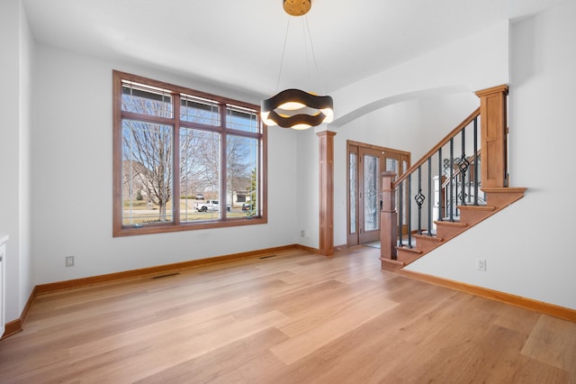 1502 Epperstone Enclave, Byron, MN 55920 - foyer with decorative columns, arched walkways, light wood-style floors, and stairway
