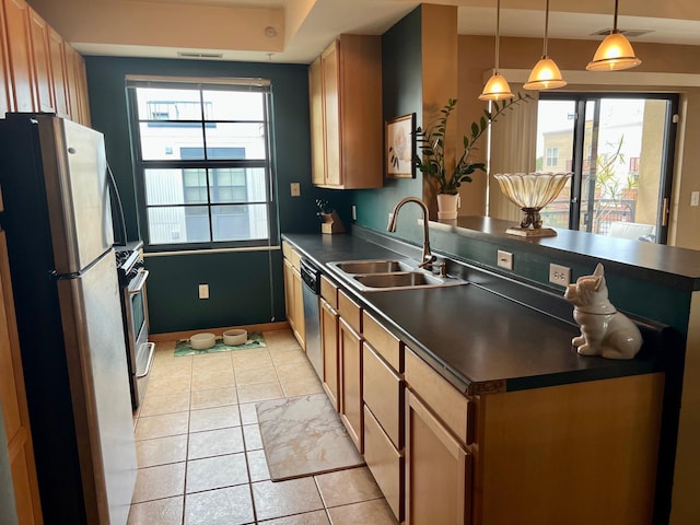 kitchen with stainless steel appliances, dark countertops, visible vents, a sink, and a peninsula