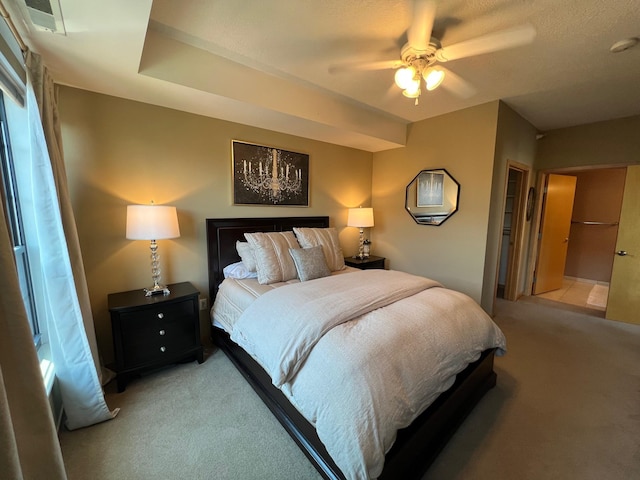 bedroom featuring a ceiling fan, visible vents, and light colored carpet