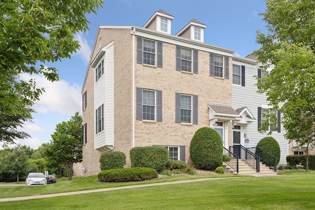 view of front of house featuring brick siding and a front yard