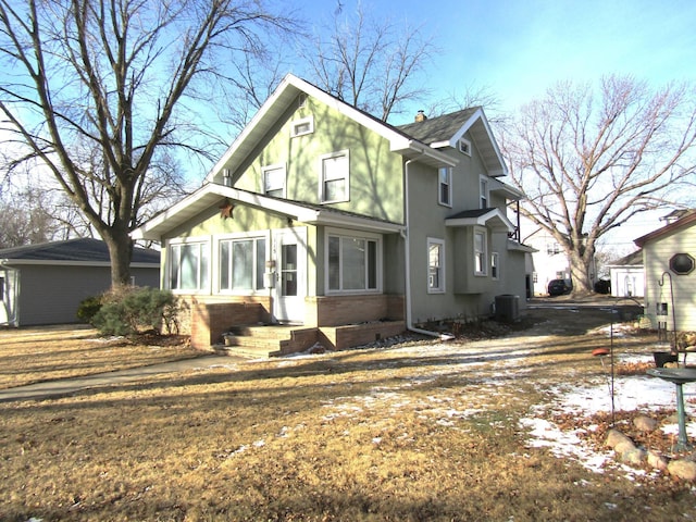 view of front of home featuring cooling unit, brick siding, and a chimney