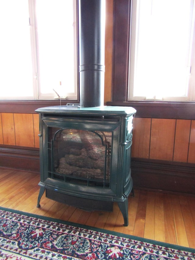 room details featuring a wood stove, wood walls, and wood finished floors