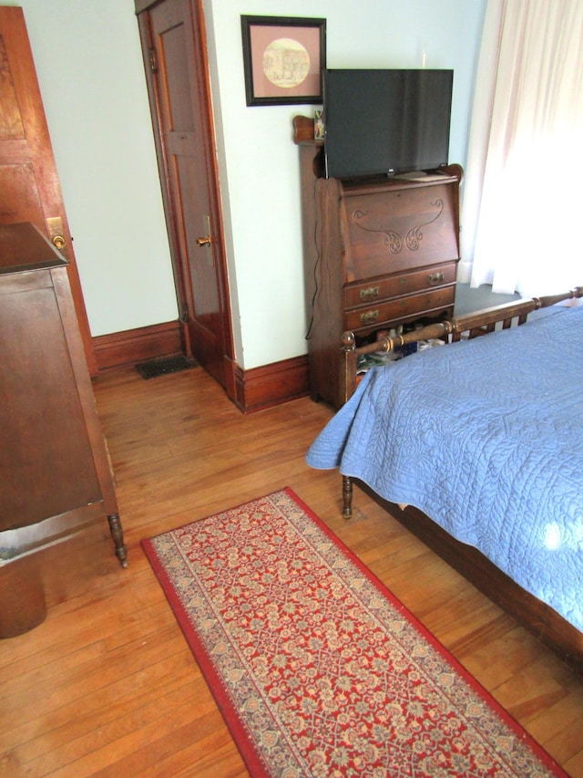 bedroom with light wood-style floors and baseboards