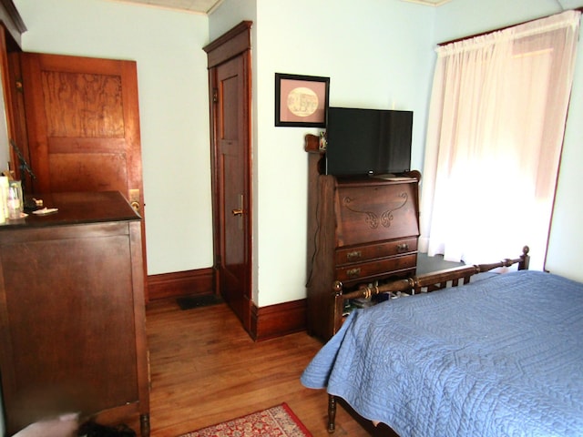 bedroom with wood finished floors and baseboards