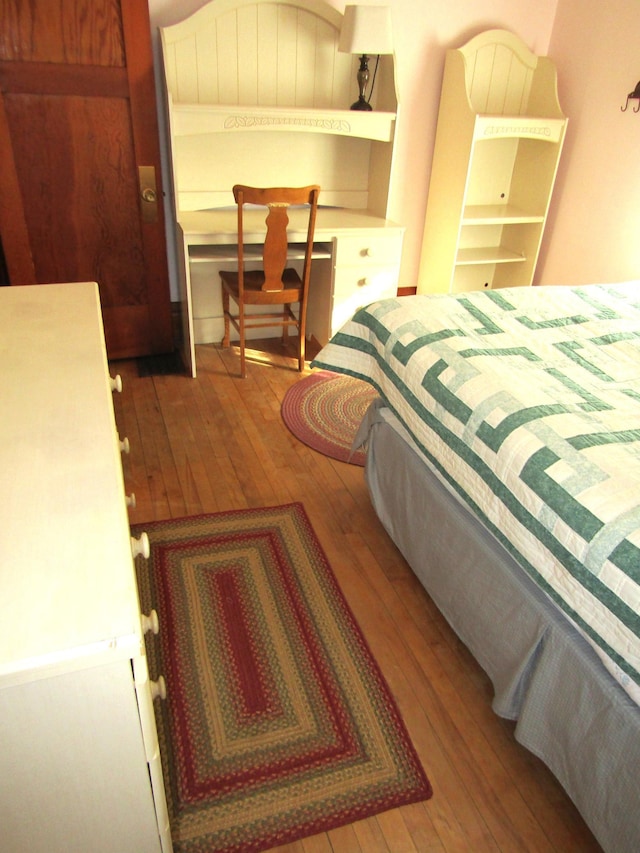 bedroom with built in study area and hardwood / wood-style flooring