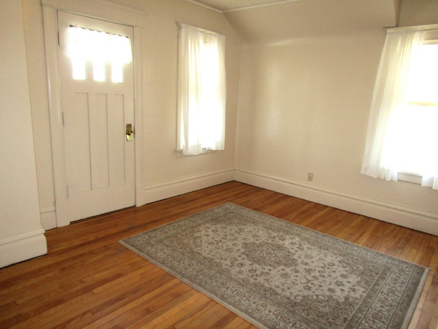 foyer entrance with plenty of natural light, wood finished floors, and baseboards