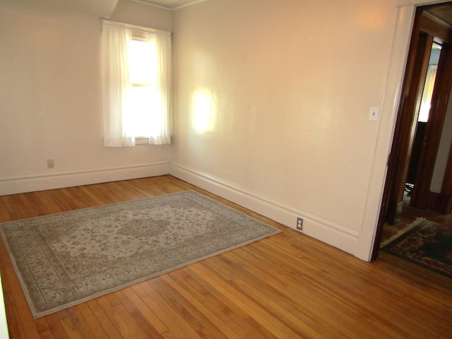 spare room featuring wood finished floors and baseboards