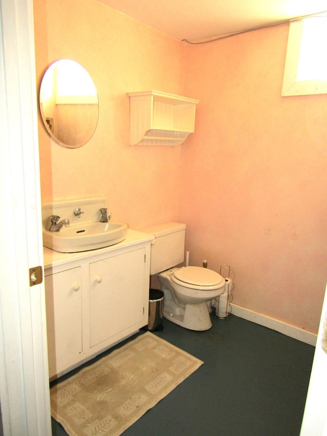 half bath featuring toilet, baseboards, and vanity