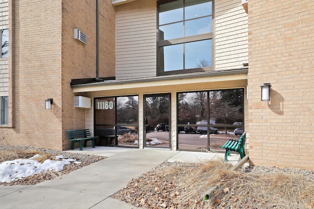 doorway to property featuring a patio and brick siding