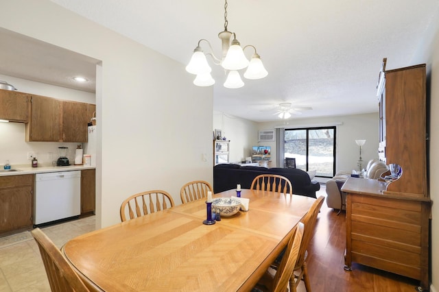 dining room featuring ceiling fan with notable chandelier, a textured ceiling, and light wood-style floors